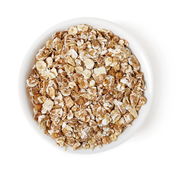 Bowl of oat flakes on white background, top view — Stock Photo, Image