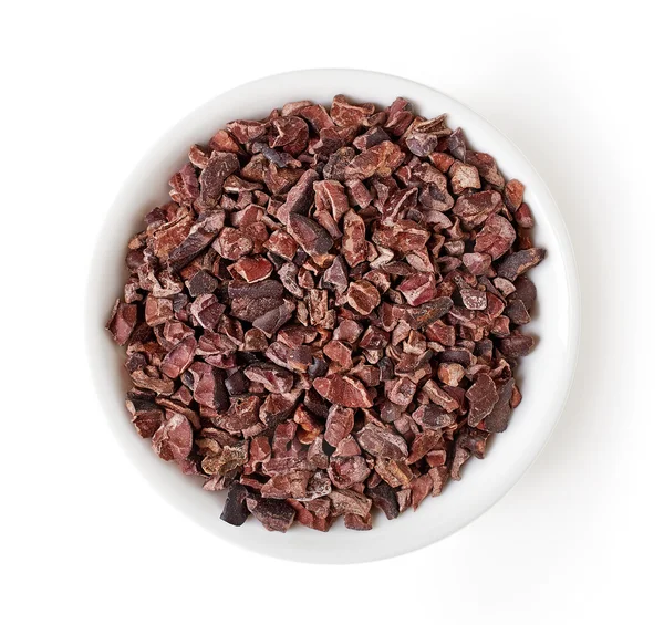 Bowl of cacao nibs isolated on white, from above — Stock Photo, Image