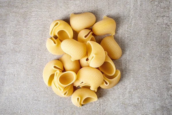 Cáscaras de pasta en la mesa de piedra, desde arriba — Foto de Stock