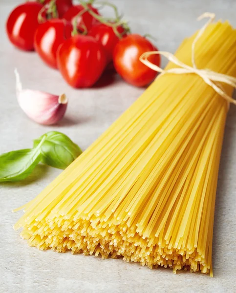 Pasta de espaguetis, queso y verduras sobre una mesa de piedra gris — Foto de Stock