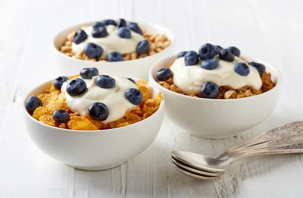 Trei tipuri de cereale cu iaurt și afine pe tabla albă — Fotografie, imagine de stoc