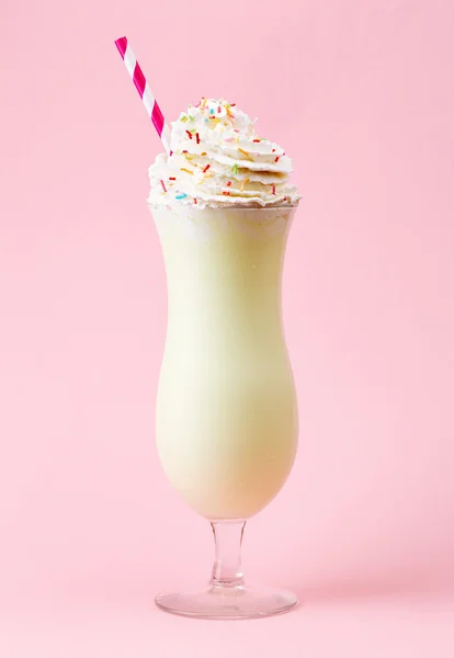 Copo de milkshake de baunilha com chantilly no fundo rosa — Fotografia de Stock