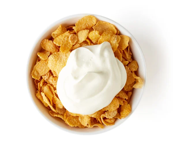 Ciotola di fiocchi di mais con yogurt isolato su bianco, dall'alto — Foto Stock