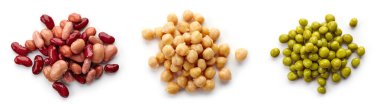Beyaz arka planda saklanmış fasulye, nohut ve yeşil bezelye yığını.