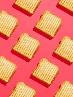 Pembe arka planda dikey kızarmış sandviç deseni, üst manzara, koyu koyu gölgeler.