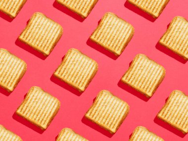 Pembe arka planda renkli tostlu sandviç deseni, üst manzara, koyu koyu gölgeler.