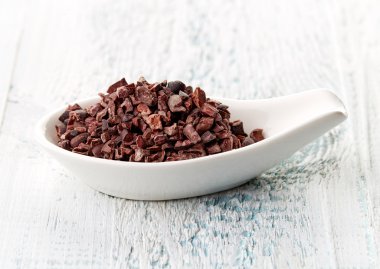 Cacao nibs in porcelain spoon clipart