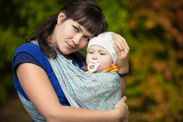 Мати зі своєю дитиною в слінгу — стокове фото