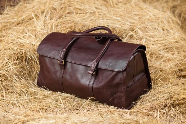 Leather bag in the hay — Stock Photo, Image