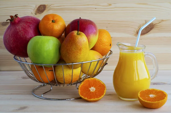 Frutas exóticas frescas en la canasta de metal y jugo en jarra . — Foto de Stock
