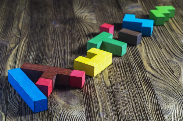 Word Autism built of wooden puzzles on a wooden background.