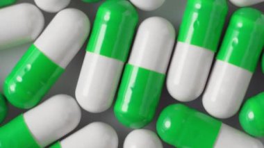 Beyaz-yeşil kapsüller, ilaç fabrikası, üst görüş, dönüş. Antiviral ilaçlar, virüs koruması, Covid-19 tedavisi.