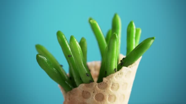 Groene Bonen Een Wafelbeker Draaien Een Blauwe Achtergrond Zwarte Sesam — Stockvideo