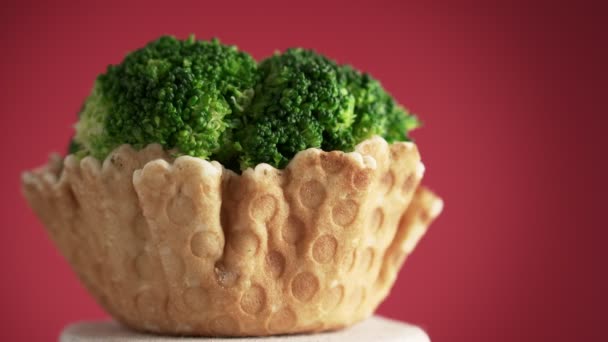 花椰菜在华夫饼杯中的花序在红色背景上旋转 食物的概念 以健康食品取代快餐 — 图库视频影像