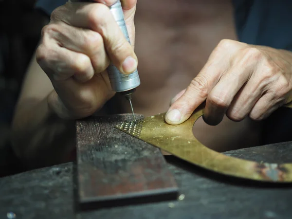 Goldsmith trabajando en un oro inacabado con sus manos trabajadoras — Foto de Stock