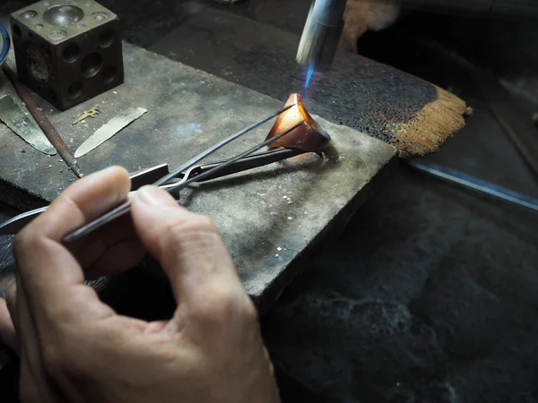 Goldsmith trabajando en un oro inacabado con sus manos trabajadoras — Foto de Stock