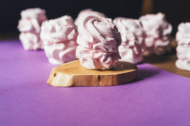 Mor arka planda taze marşmelovlar. Zephyr, kremalı pasta. Ev yemeği konsepti, tatlılar. Minimalizm, düz alan, telif alanı.