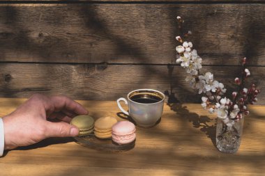 Sokak kafesinde kahvaltı kavramı. Ahşap zemin üzerinde badem kurabiyesi olan kahve..