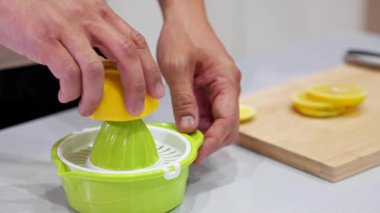 El sıkma makinesine limon sıkan el yapımı meyve suyu ve tohumlar. Gıda blogları, detoks temaları, narenciye içeceği hazırlama ve taze malzeme görselleri için ideal..