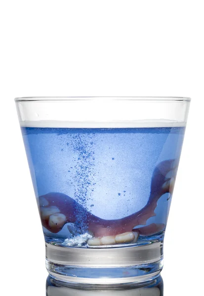 Een gebit in een glas met water te reinigen. Goede hygiëne — Stockfoto