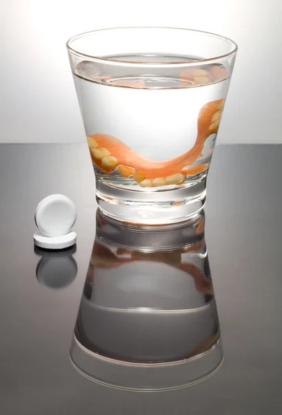 Bir bardak su ile bir takma diş Temizleme. Uygun hijyen.