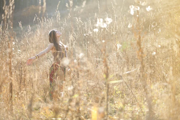 Menina na grama no pôr do sol — Fotografia de Stock