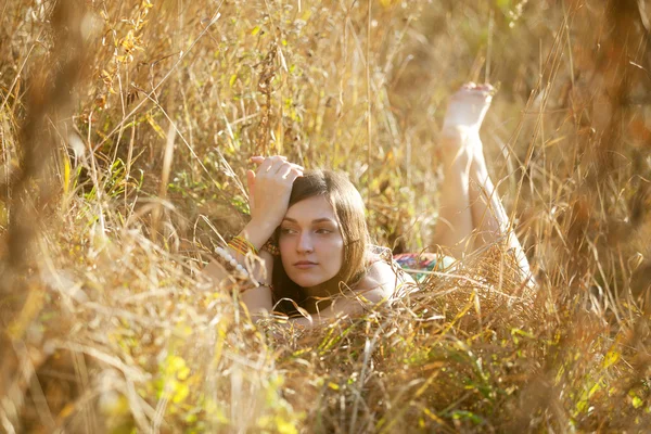 Menina na grama no pôr do sol — Fotografia de Stock