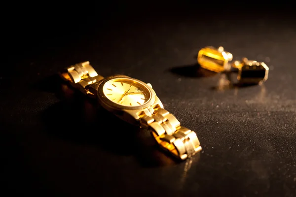Relógios de ouro e abotoaduras em um fundo preto — Fotografia de Stock