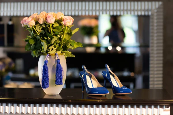 Svatební kytice a boty na stole — Stock fotografie