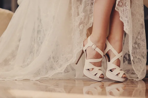 Very beautiful white wedding sandals on female feet — Stock Photo, Image