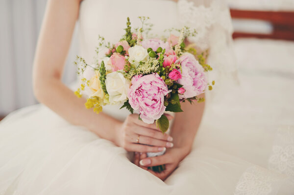 Very gentle wedding bouquet in hands of the bride