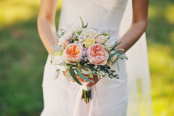 Great, very gentle wedding bouquet in hands of the bride
