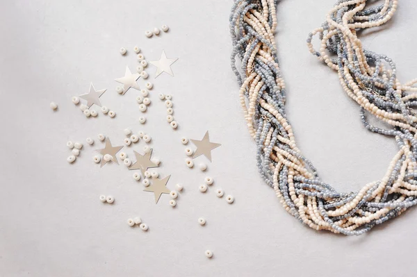 White beads are scattered near a necklace Stock Image