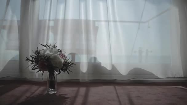 Wedding bouquet against a white curtain in a gostitsitsa in the morning at the bride — Stock Video