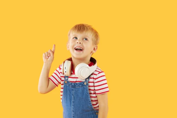 Glimlachend Jongetje Luistert Graag Naar Muziek Hoofdtelefoon Kleurrijke Gele Achtergrond — Stockfoto