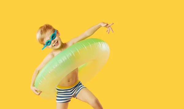 一个带着霓虹灯充气橡胶圆圈的游泳护目镜 带着快乐的小男孩的画像 在黄色的背景下被隔离 暑假6张滑稽的脸 — 图库照片