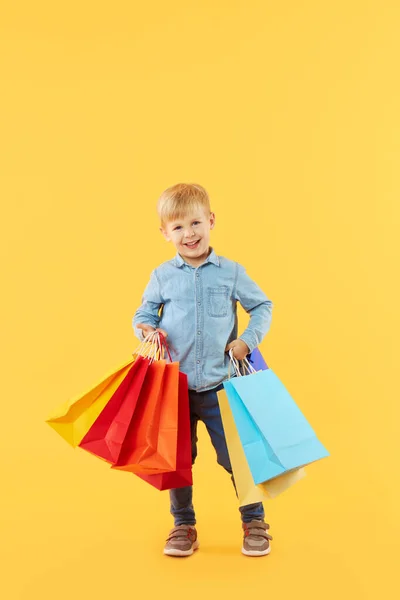 Venda Produtos Infantis Retrato Diversão Menino Fundo Amarelo Segurando Sacos — Fotografia de Stock