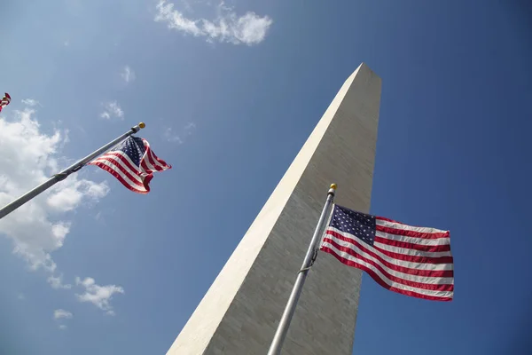 Rüzgarda dalgalanan Amerikan bayraklarıyla Washington Anıtı.