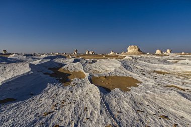 Mısır 'daki Farafra vahası yakınlarındaki Beyaz Çöl' de beyaz mineral kayaları ve kumla güzel bir manzara.