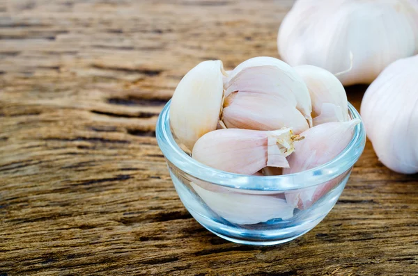 Aglio in boel di vetro su sfondo vecchio di legno — Foto Stock