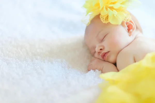 Újszülött lány alszik, sárga szoknya, kalap — Stock Fotó