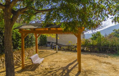 Pergola ile Finestrat, Alicante, İspanya, parkta bir bankta bir ağacın altında