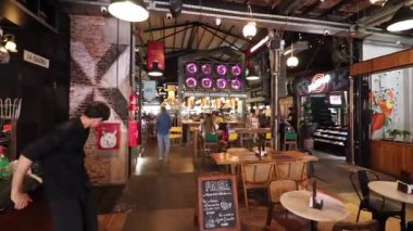 La Plata City Arjantin 'deki Baxar pazarının içi. Gıda tezgahları, endüstriyel tasarım ve modern atmosferde yürüyen insanlar..