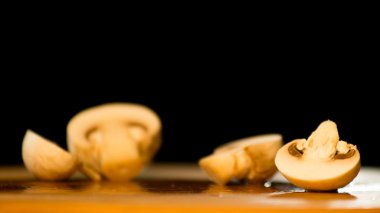 siyah bir arka plan üzerine kurulu izole kahverengi bir kesim üzerinde champignon mantar