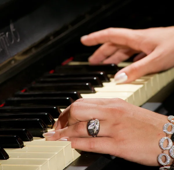 Das Mädchen spielt Klavier, Hände und Tasten schließen sich — Stockfoto
