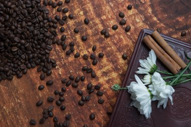 kahve çekirdekleri, tarçın ve ahşap arka plan üzerinde kitap