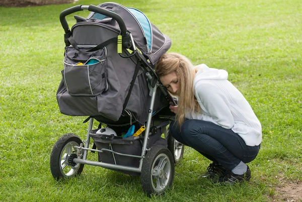 Young mother and son in stroller Stock Image