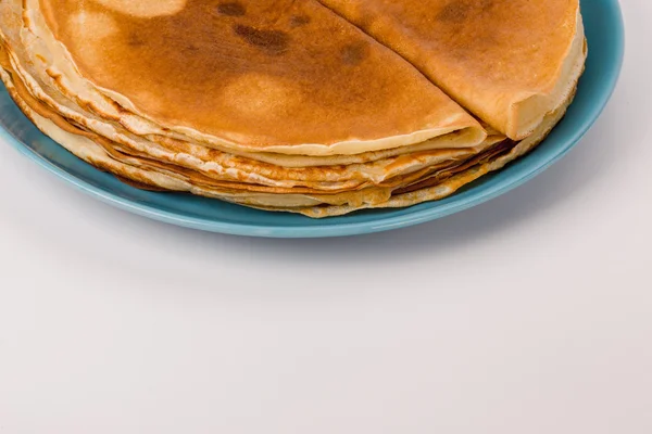 Pancakes on a blue plate white background — Stock Photo, Image