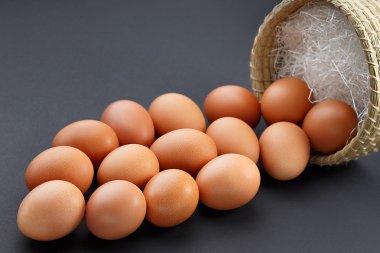 Siyah bir zemin üzerine bir hasır sepet yumurta