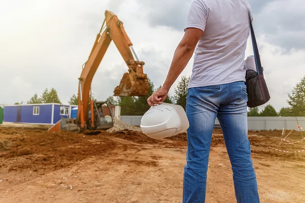 Uomo in jeans, con in mano un casco — Foto Stock